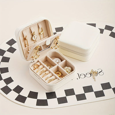 Un elegante y creativo joyero portátil para anillos y pendientes, con una cremallera y una tapa abatible para facilitar su transporte. Este estuche de viaje incluye un espejo y está diseñado para collares, pendientes y anillos, joyeros.